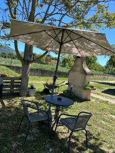 a table and two chairs and an umbrella at Cuore di Legno Country House in Spoleto +35 photos