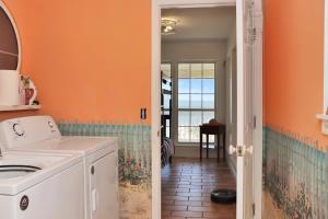 a laundry room with an orange wall at White Pelican by Pristine Property Vacation Rentals in Indian Pass +65 photos