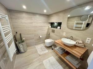 a bathroom with a sink and a toilet and a mirror at La Casetta in Malden +26 photos