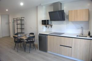 a kitchen with a small table and a counter top at IG Apartamentos in Palas de Rei