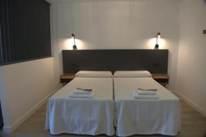 a bedroom with a bed with two pillows on it at IG Apartamentos in Palas de Rei