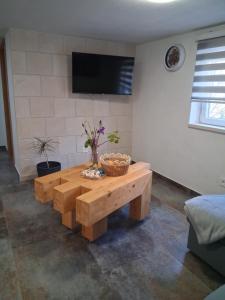 a living room with a wooden coffee table and a tv at Apartman Golden Stone in Ivanica
