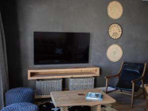 a living room with a tv and a table and chairs at PenthouseOne on the Canals in Marina Glades