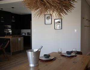a wooden table with two plates and wine glasses at PenthouseOne on the Canals in Marina Glades
