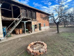 an old brick building with a fire pit in the yard at Privatzimmer auf Pferdehof in Vŭbel
