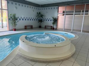 a large pool with a hot tub in a building at Chalet à l'océan in Bias +2 photos