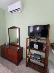 a room with a tv and a dresser and a mirror at Forest Retreat Near the Sea Kouvaras in Kouvarás
