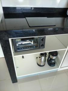 a kitchen with a toaster oven on a shelf at Lazer , Descanso, Pesca e Praia in Iguape