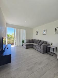 a living room with a couch and a television at Spacious 2BR with ensuite and AC unit and balcony near Heathrow in Cranford