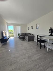 a living room with a couch and a table at Spacious 2BR with ensuite and AC unit and balcony near Heathrow in Cranford