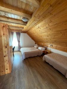 a bedroom with two beds and a wooden ceiling at Guest House Plitvice Waterfall in Plitvička Jezera