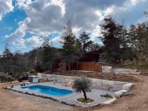 a swimming pool in a yard next to a fence at Secluded design cabin forest retreat in Cyprus in Kappedhes