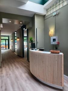 an office lobby with a reception desk with a laptop at Hotel Le Colibri in Aix-les-Bains