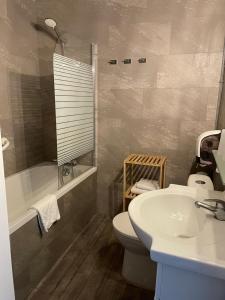 a bathroom with a sink and a toilet and a tub at Hotel Le Colibri in Aix-les-Bains +23 photos