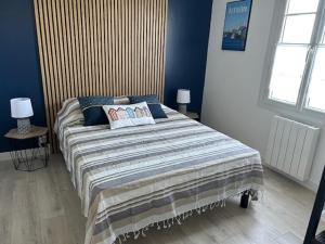 a bedroom with a large bed with blue walls at Terredesel Oleron in Saint-Denis-dʼOléron