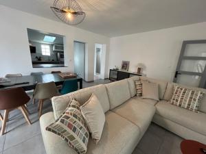 a living room with a couch and a dining room at Terredesel Oleron in Saint-Denis-dʼOléron