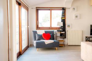 a living room with a blue chair with a red heart pillow at La Mouette Bleue maison de ville individuelle et climatisée in Martigues