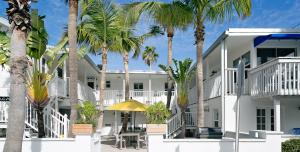 a white building with palm trees in front of it at Inn on the Beach in St. Pete Beach