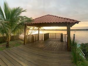 a wooden deck with a gazebo next to the water at Lazer , Descanso, Pesca e Praia in Iguape