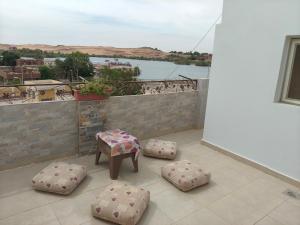 a balcony with a table and four ottomans at sunset in Abu Simbel