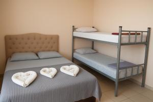 two beds with hearts shaped pillows on them at Pousada Recanto dos Pássaros in Linhares