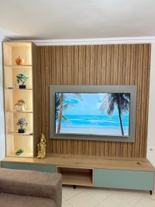a living room with a television on a wooden wall at luxury studio's J&M in Sarandë