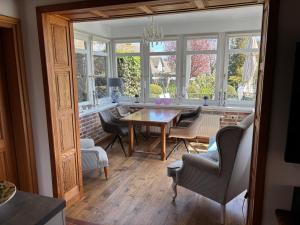 a living room with a table and chairs and windows at Fachwerkhaus in Ahrenshoop