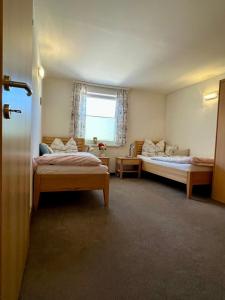 a room with two beds and a window at Zeit/-Los in Irdning