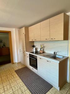a kitchen with wooden cabinets and a sink at Zeit/-Los in Irdning