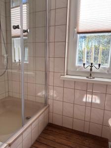 a bathroom with a shower and candles in a window at Hundeurlaub - Tiny House im Wald in Tanna +97 photos