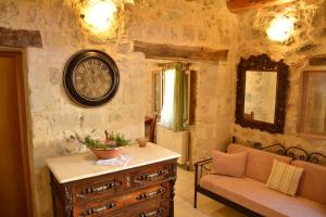 a living room with a clock on the wall at Roukouneli Traditional Stone House - Terrace & BBQ in Arménoi