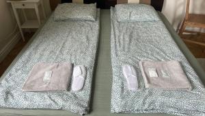 two beds with slippers and towels on top of them at K14 Stay 1 in Riga