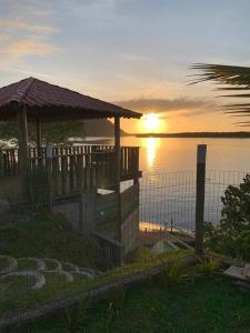 a sunset over the water with a gazebo at Lazer , Descanso, Pesca e Praia in Iguape