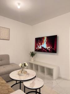 a living room with a couch and a tv on the wall at Casa Bianca - Maison à Orléans in Orléans