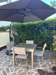 a table and chairs with an umbrella on a patio at Minerva in Viareggio