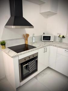 a white kitchen with a sink and a microwave at Casa Bianca - Maison à Orléans in Orléans