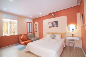 a bedroom with a large bed and a chair at An Du Boutique Stay in Dong Hoi