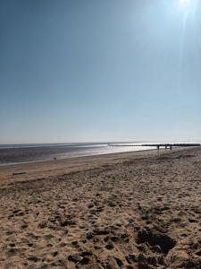 a beach with people walking on the sand at Highwood mews in Cleethorpes