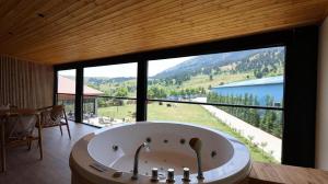a large bath tub in a room with a large window at Perla e Tomorrit EZ in Ujanik