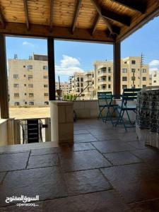 an outdoor patio with chairs and tables and buildings at Jordan Amman in Amman