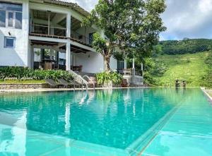 a large swimming pool in front of a house at Leaf Olu Ella in Yatiyantota