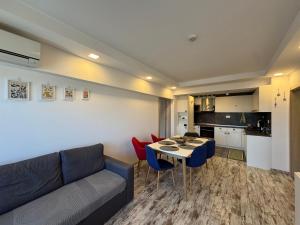 a living room with a couch and a table and chairs at Киво апарт Созопол in Sozopol