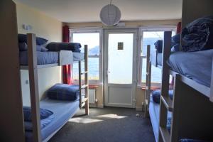 a room with three bunk beds and a window at Loch Ness Lochside Hostel - Over 16s Only in Invermoriston +25 photos