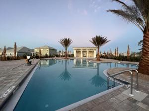 a large swimming pool with palm trees and a house at Backwater Bliss by Pristine Properties Vacation Rentals in Saint Joe Beach