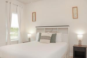 a white bedroom with a white bed and a window at Backwater Bliss by Pristine Properties Vacation Rentals in Saint Joe Beach +61 photos
