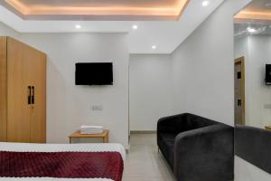 a living room with a couch and a tv on the wall at Hotel Royal City Palace in Kolkata