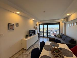 a living room with a couch and a tv at Киво апарт Созопол in Sozopol