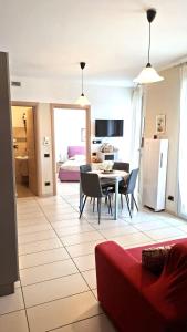 ein Wohnzimmer mit Tisch und Stühlen und ein Schlafzimmer in der Unterkunft La trifula bianca apts. in Alba