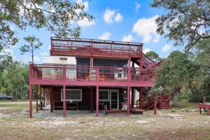a red house with a balcony and a deck at Wales Pod by Pristine Properties Vacation Rentals in Indian Pass