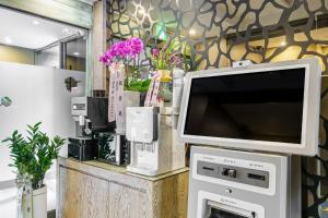 a tv sitting on top of a machine with flowers at Ilsan Hotel K in Goyang